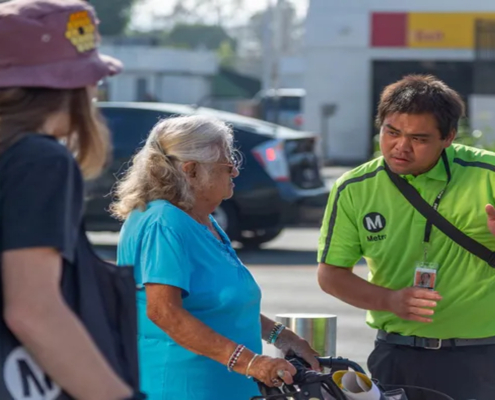 A transit ambassador assists two people by giving them directions.