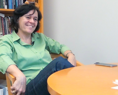 professor seated at a table in her office
