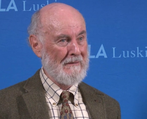 man with gray beard against blue background