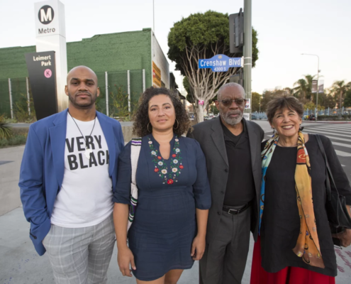 four people stand outside a Metro stop in Los Angeles