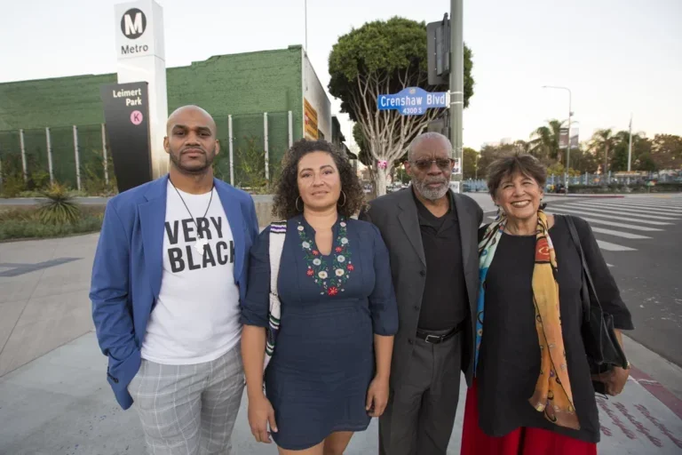 four people stand outside a Metro stop in Los Angeles