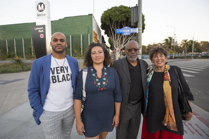 four people stand outside a Metro stop in Los Angeles