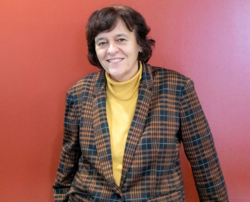 woman stands in front of red background