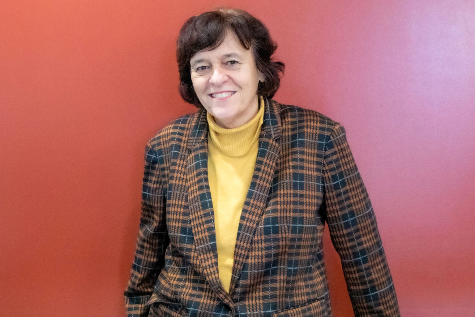 woman stands in front of red background