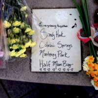 Flowers near sign of mourning for mass shootings