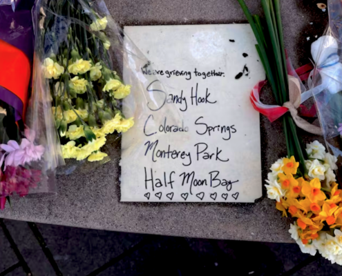 Flowers near sign of mourning for mass shootings