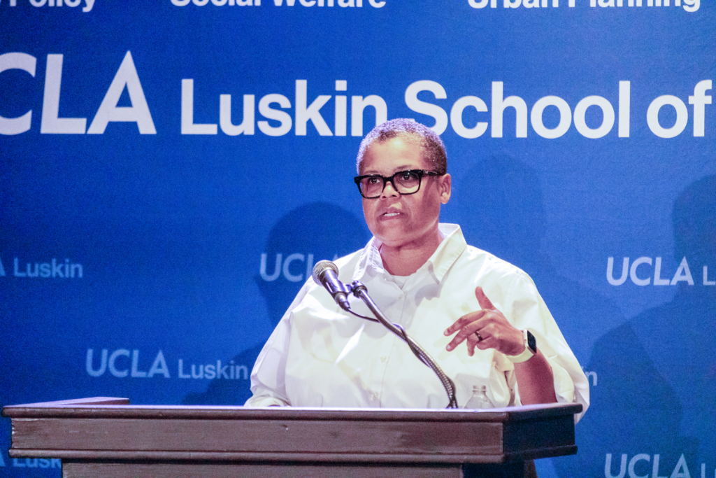 woman with glasses and white shirt at podium