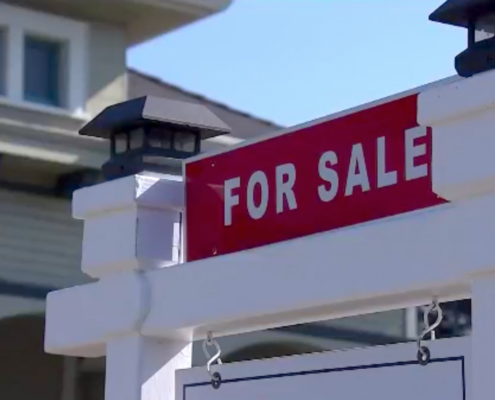 "For Sale" sign in front of house