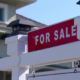 "For Sale" sign in front of house