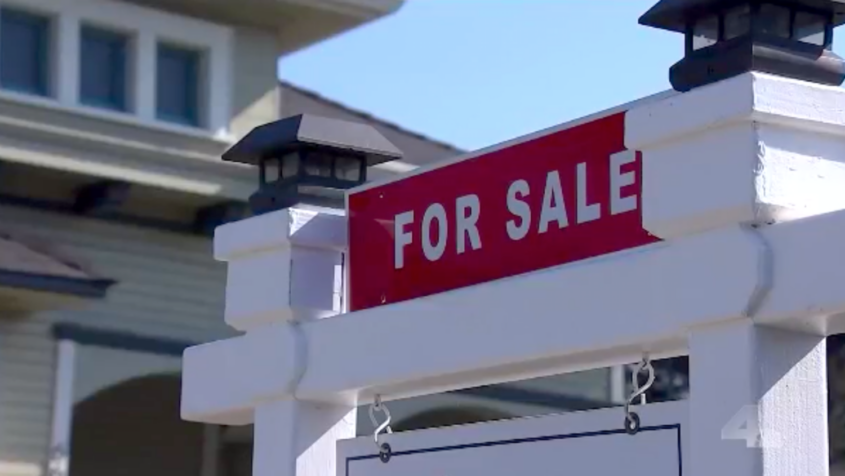 "For Sale" sign in front of house