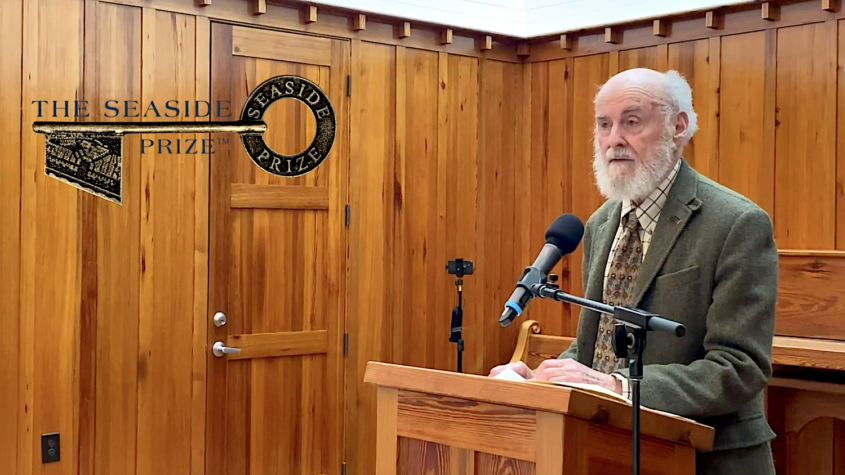 man with gray hair and beard at podium
