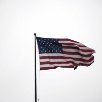 American flag waving in front of a white background.