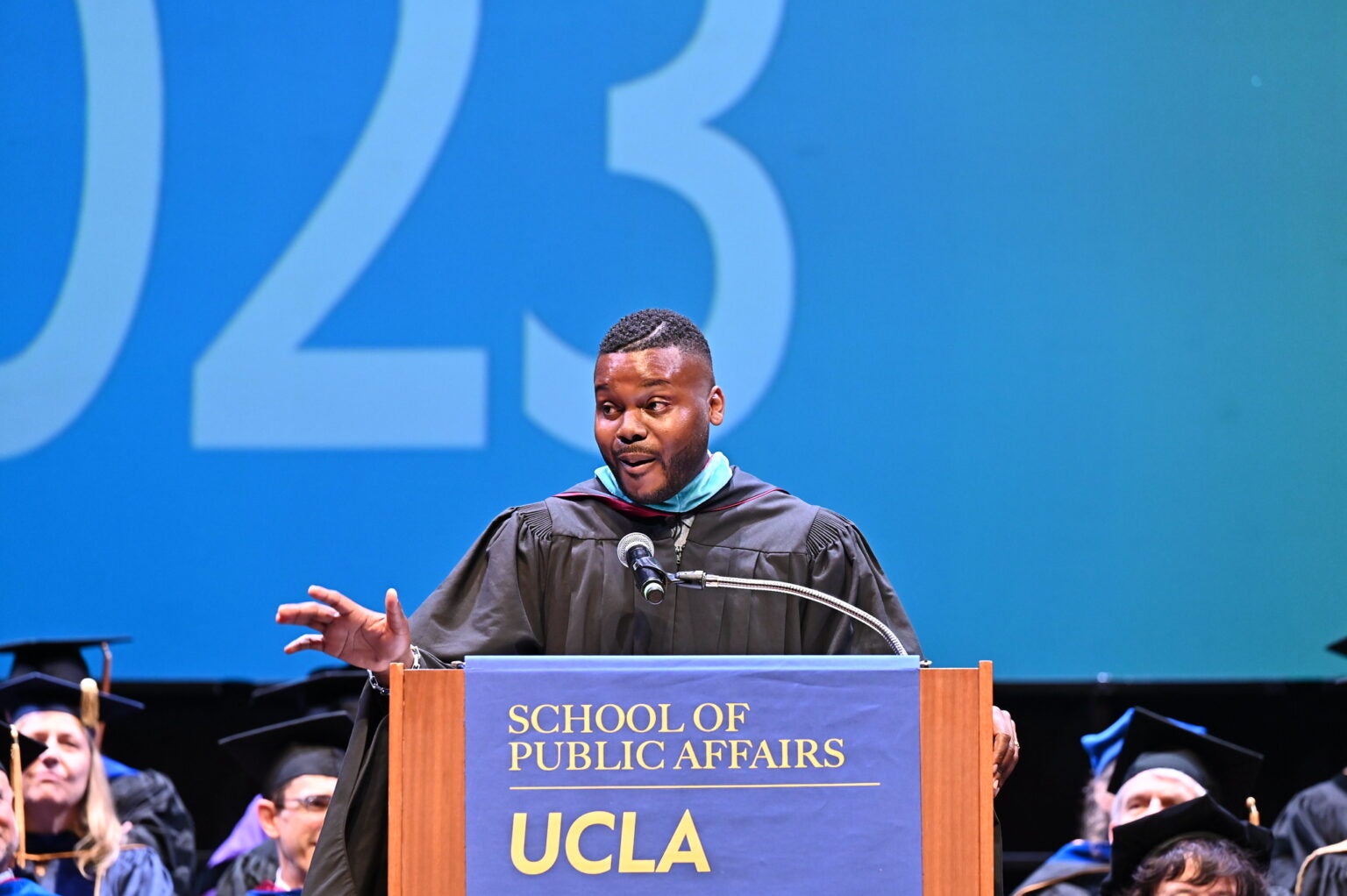 man in academic regalia at podium