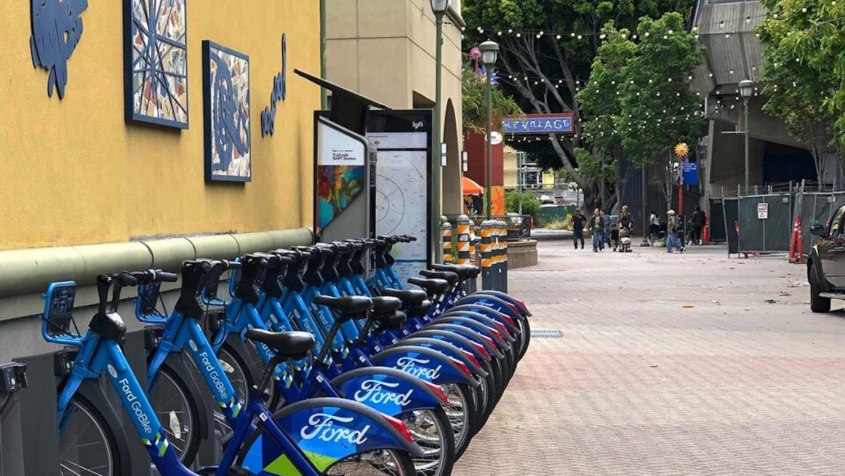 line of blue bicycles for rent