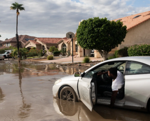 Man in car on flooded road