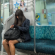 young woman sitting alone on subway