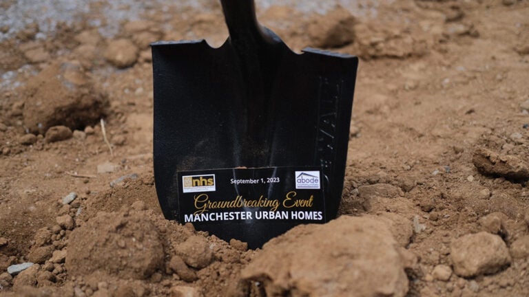 shovel with writing digs into dirt at project site