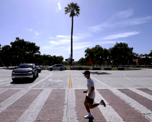 Man running in intersection with palm tree in background