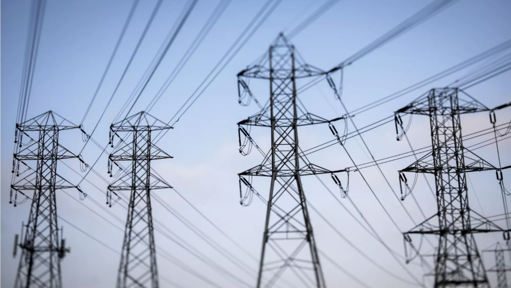 power lines silhouetted against blue sky