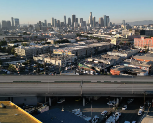 empty stretch of freeway with Los Angeles skyline in background