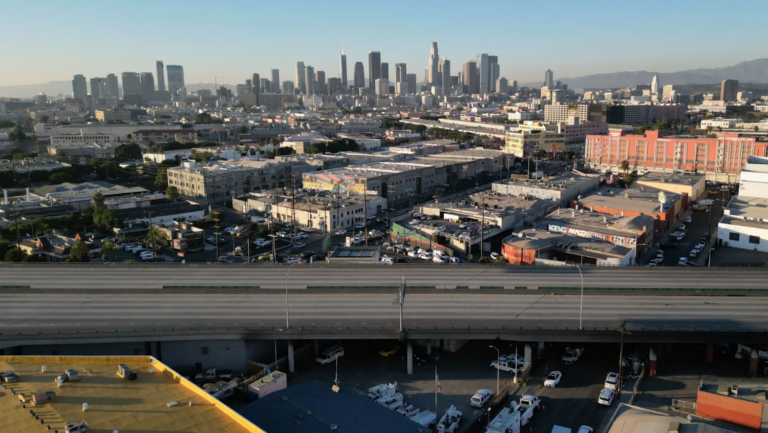 empty stretch of freeway with Los Angeles skyline in background