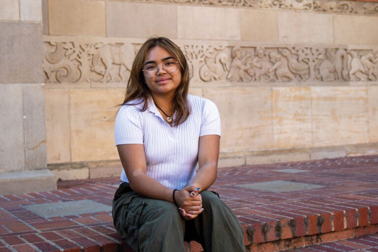 young woman sits on steps outside a building