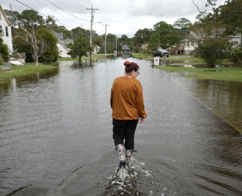 woman walking through flooded street