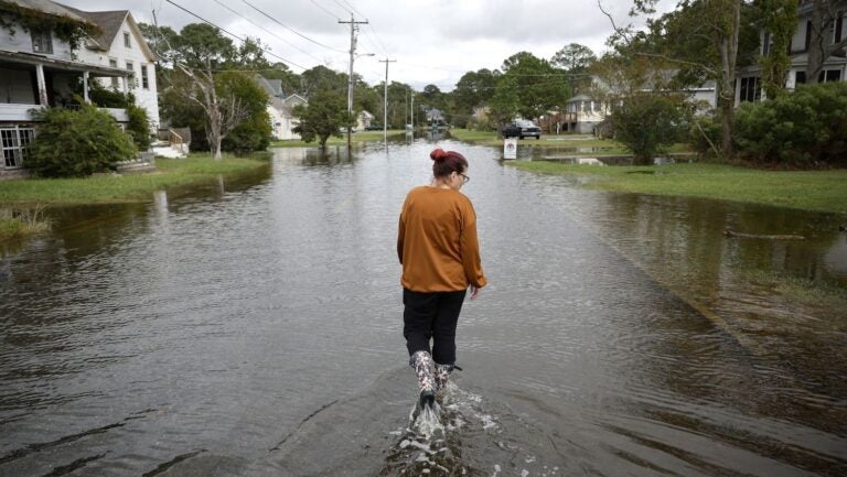 woman walking through flooded street