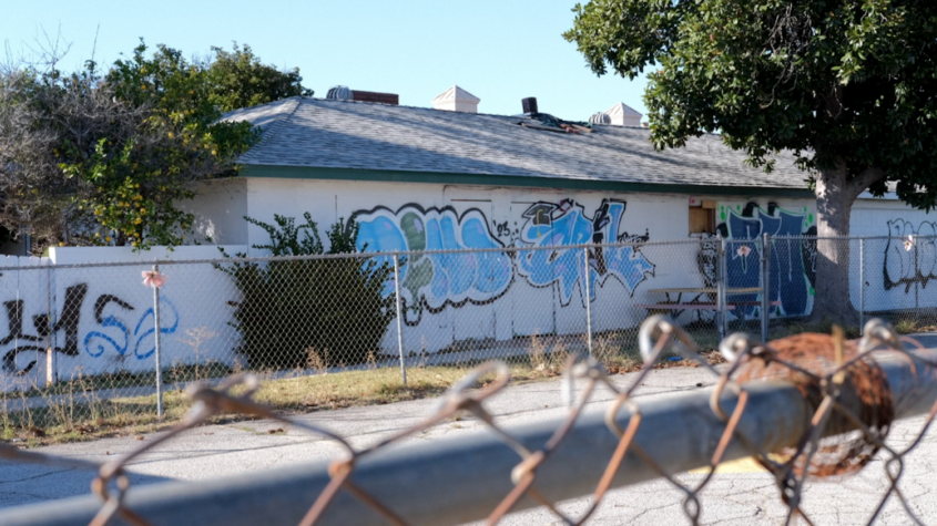 graffiti on building behind chain-link fence