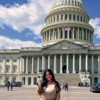 Young woman stands in front of the U.S. Capitol.