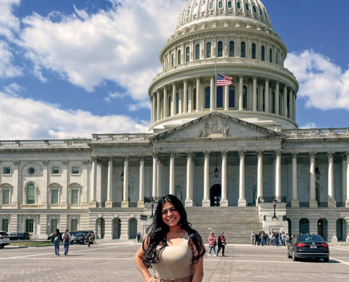 Young woman stands in front of the U.S. Capitol.