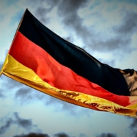 flag with black, red, yellow stripes against stormy sky