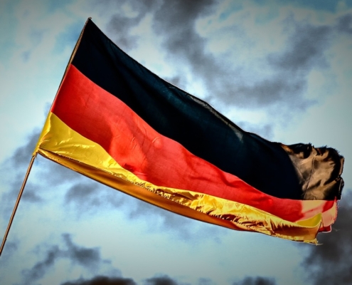 flag with black, red, yellow stripes against stormy sky