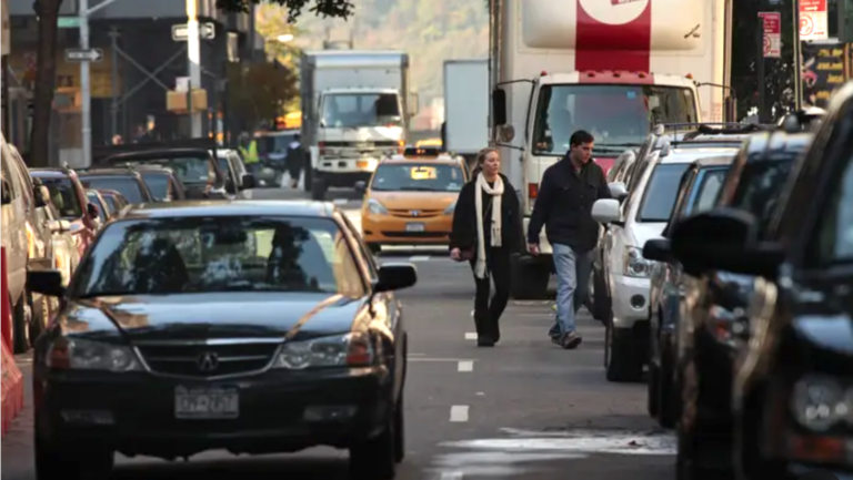 people and cars on busy street