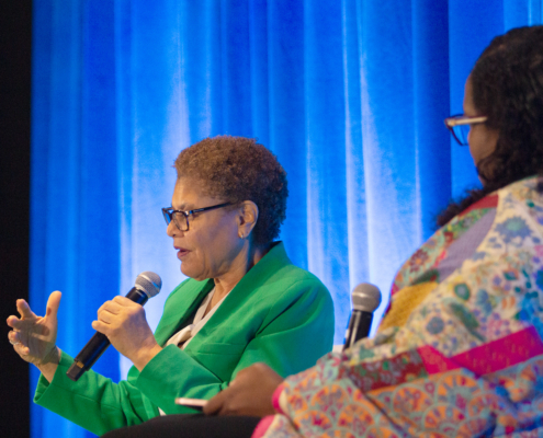 woman in green suite gestures while she speaks