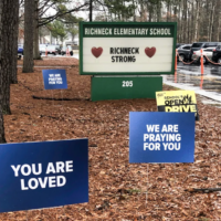 front of elementary school with signs expressing encouragement