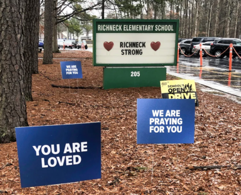front of elementary school with signs expressing encouragement