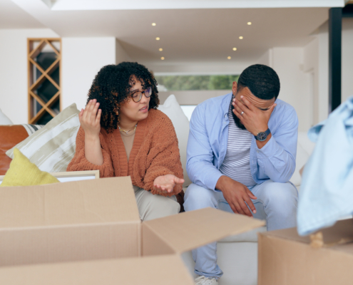 a man and woman surrounded by moving boxes