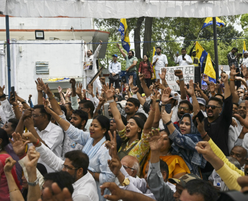people with arms raised at a rally in India