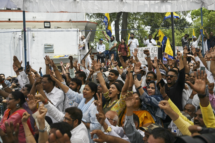 people with arms raised at a rally in India