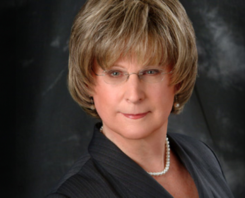 portrait photo of Michelle Dennis wearing glasses and a dark top