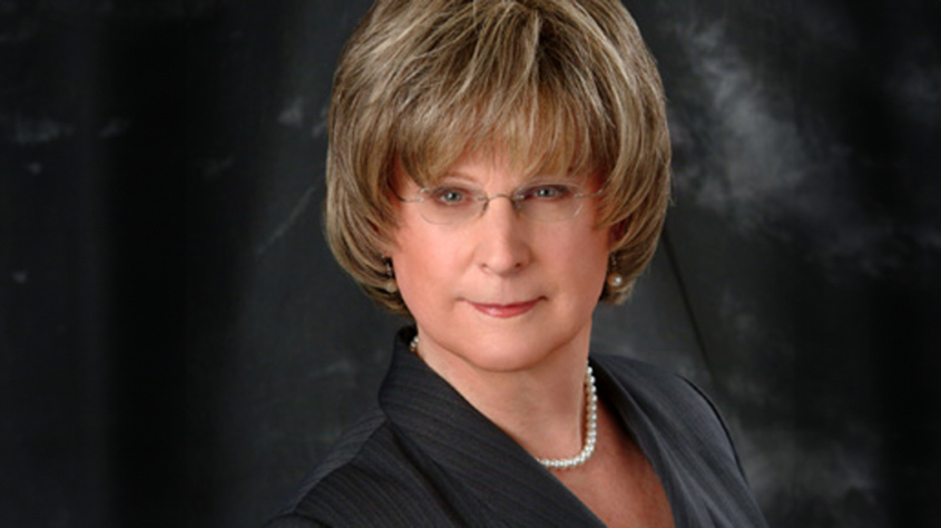 portrait photo of Michelle Dennis wearing glasses and a dark top