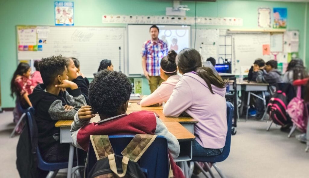 Classroom scene with teacher standing and students sitting