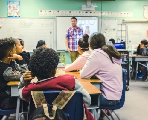 Classroom scene with teacher standing and students sitting