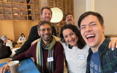snapshot of four men and a woman laughing as they take a selfie