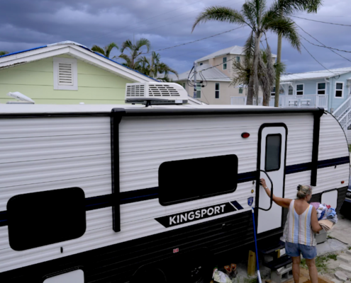 woman entering RV under threatening skies