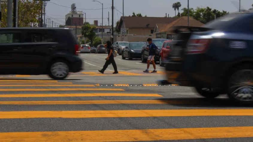 children in a crosswalk as cars speed by