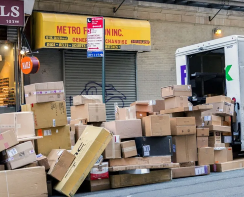 boxes piled behind a FedEx truck on a city street