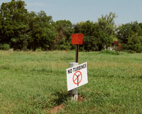 sign saying "No Turbines" in grassy field