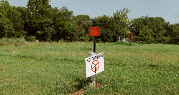 sign saying "No Turbines" in grassy field